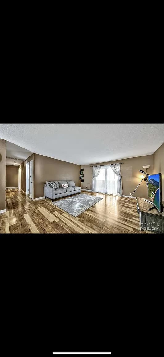 Brown-walled living room with a single undersized loveseat and a too-small rug before the Columbus Way transformation